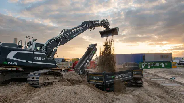 RAHN Erdbau Bagger 922 bei Erdarbeiten im Sonnenuntergang